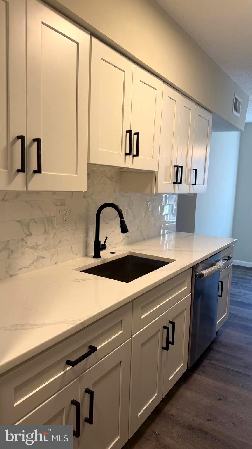 613 Washington Place, Unit 13 Chesterbrook, PA 19087 - Photo 31 of 64 a kitchen with stainless steel appliances white cabinets a sink and a large window