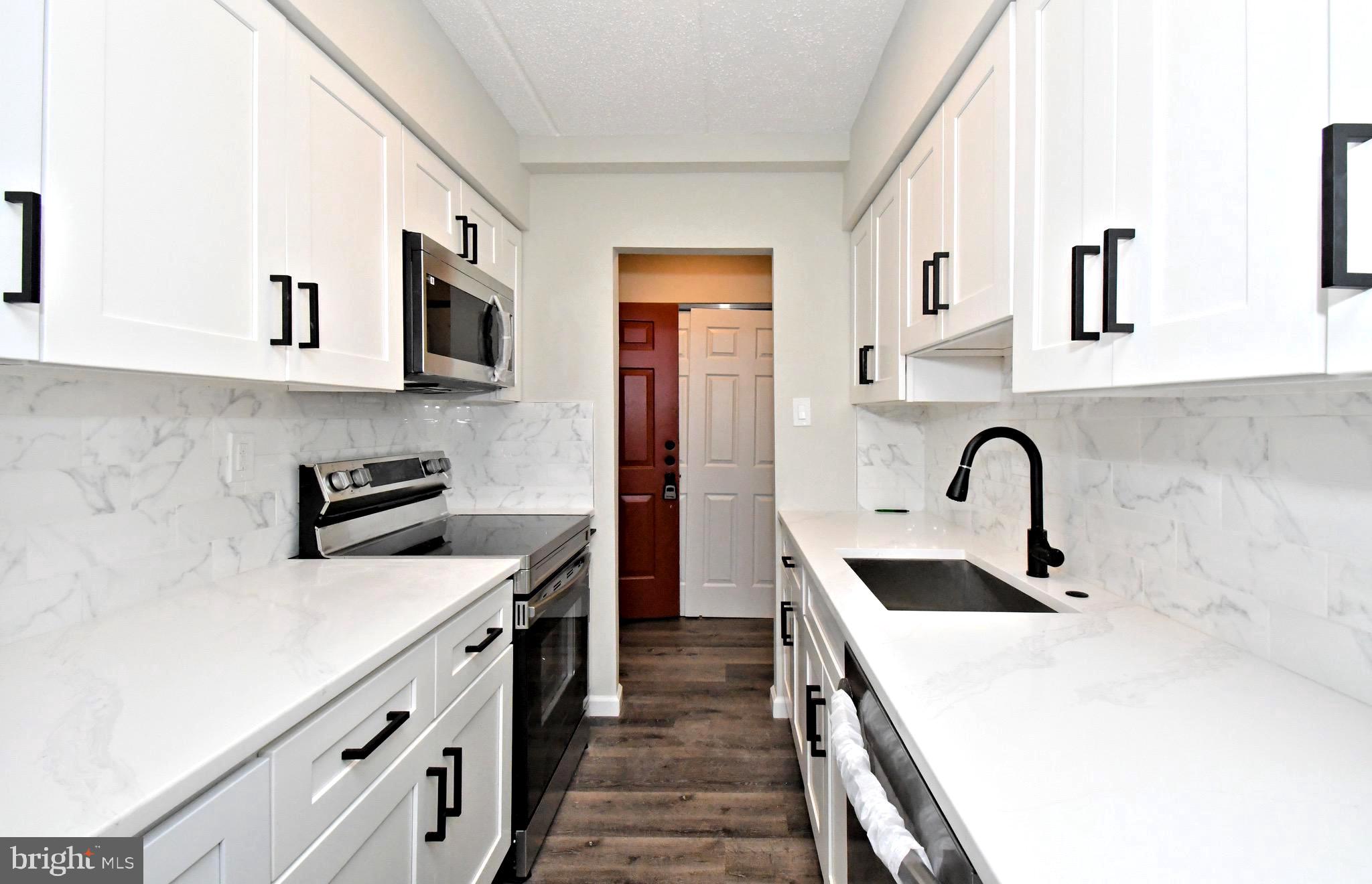 613 Washington Place, Unit 13 Chesterbrook, PA 19087 - Photo 36 of 64 a kitchen with stainless steel appliances granite countertop a sink and a stove top oven