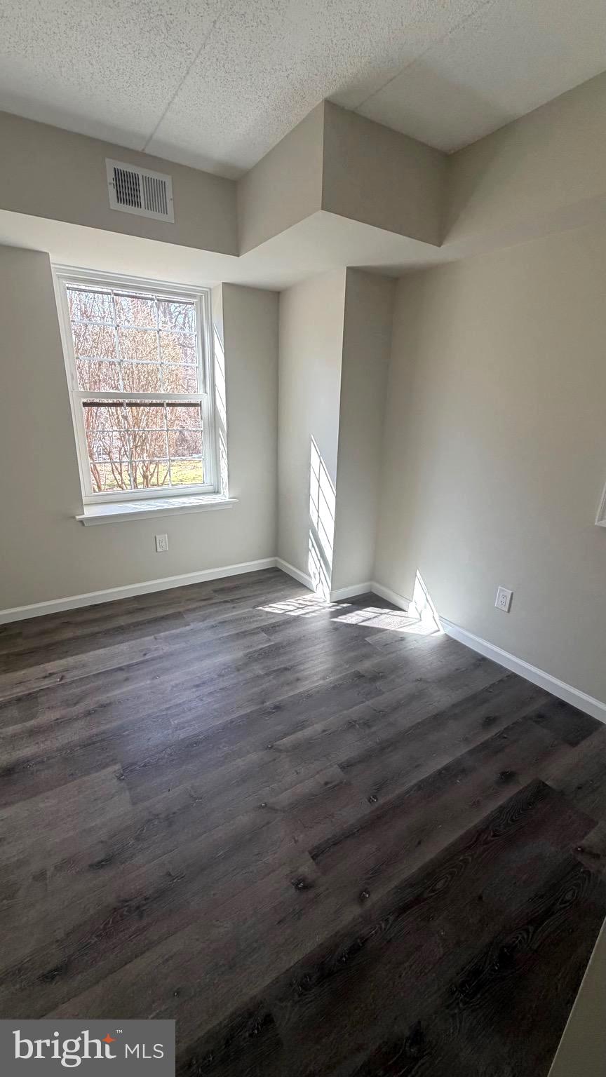 613 Washington Place, Unit 13 Chesterbrook, PA 19087 - Photo 60 of 64 an empty room with wooden floor and windows