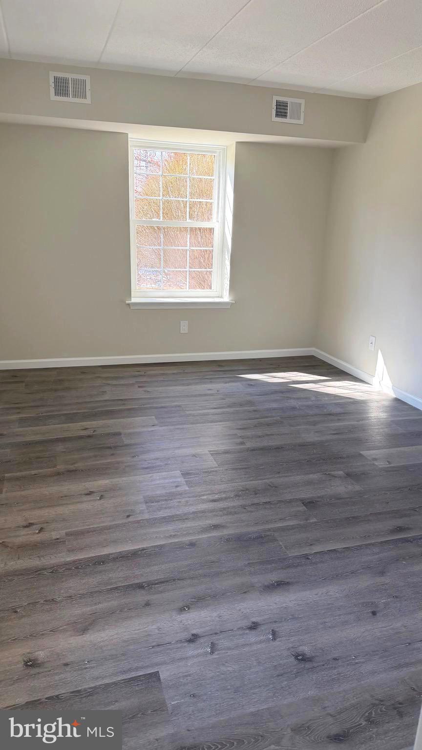 613 Washington Place, Unit 13 Chesterbrook, PA 19087 - Photo 64 of 64 a view of an empty room with wooden floor and a window