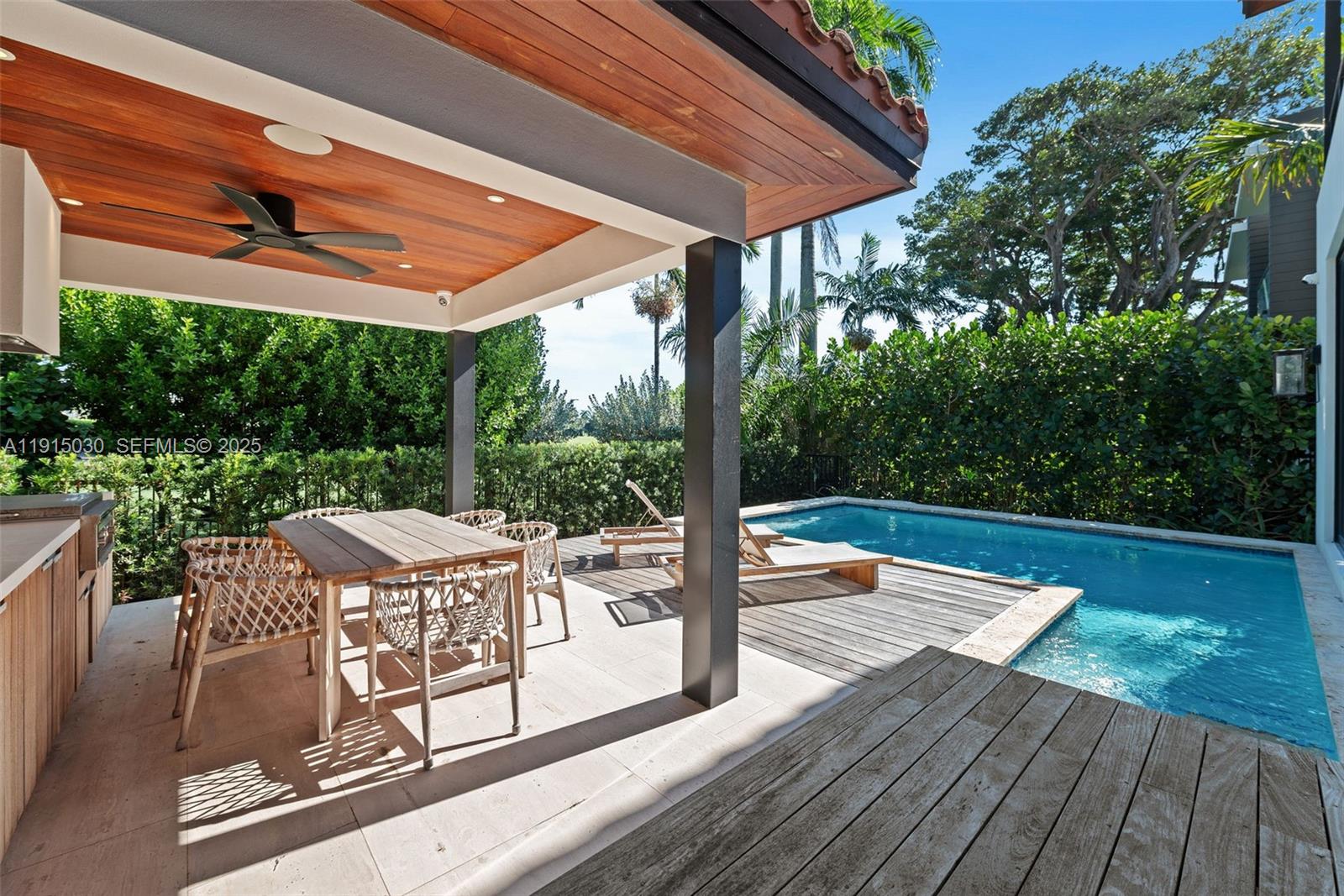 5831 Alton Road Miami Beach, FL 33140 - Photo 13 of 48 a view of a patio with wooden floor a yard tables and chairs