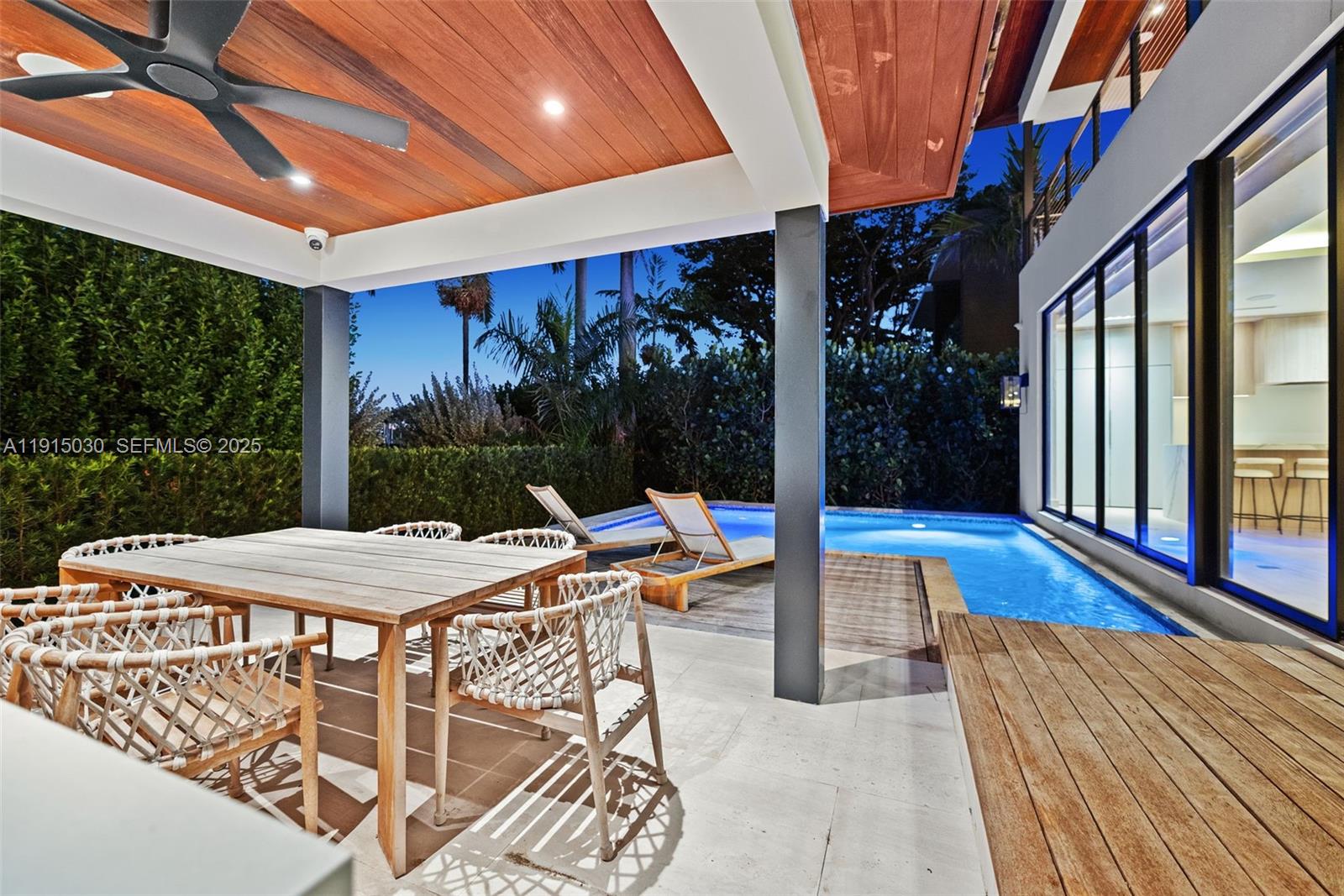 5831 Alton Road Miami Beach, FL 33140 - Photo 36 of 48 a view of a patio with a table and chairs under an umbrella with a barbeque