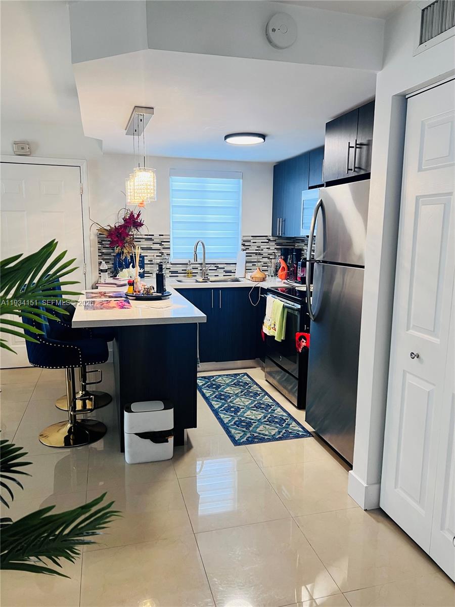 3101 Southwest 27th Avenue, Unit 101 Miami, FL 33133 - Photo 3 of 11 a kitchen view with a refrigerator and a sink