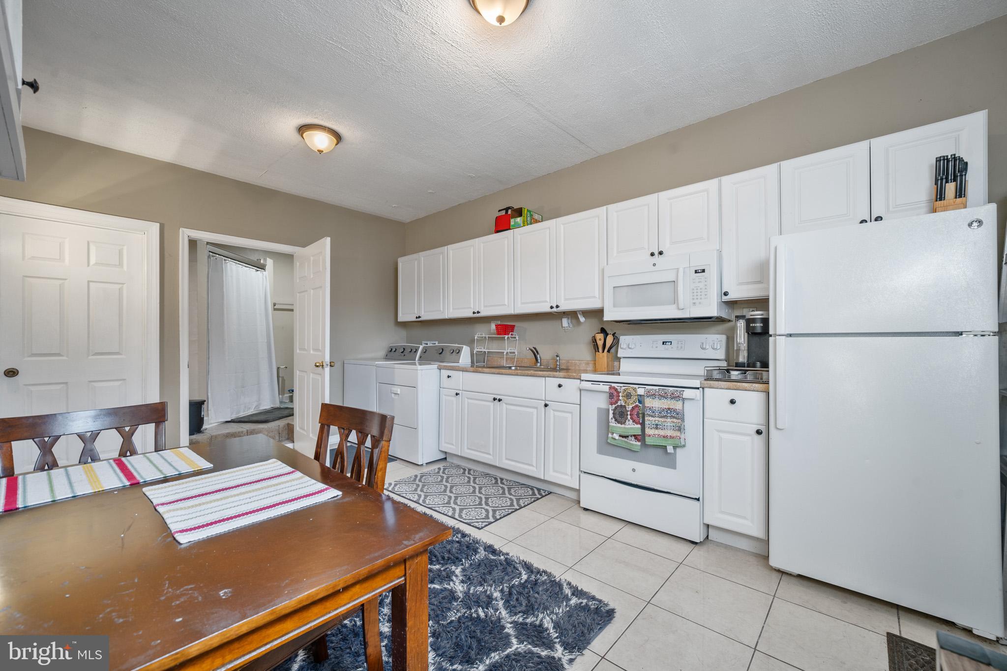 5918 Old Croom Station Road Upper Marlboro, MD 20772 - Photo 62 of 89 a kitchen with stainless steel appliances a refrigerator sink and white cabinets