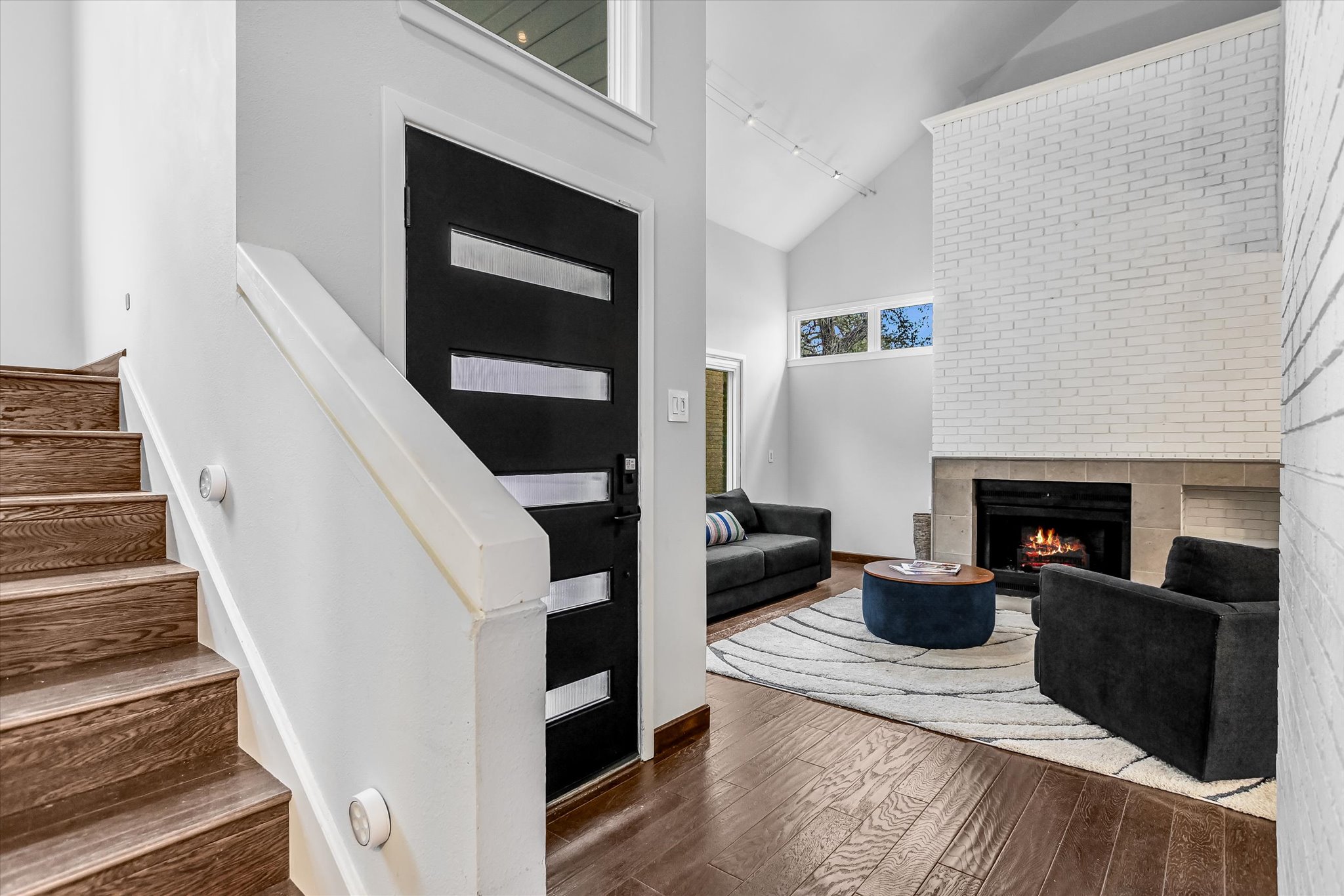5622 Parade Ridge Austin, TX 78731 - Photo 4 of 24 Entryway featuring high vaulted ceiling, a fireplace, and stairway
