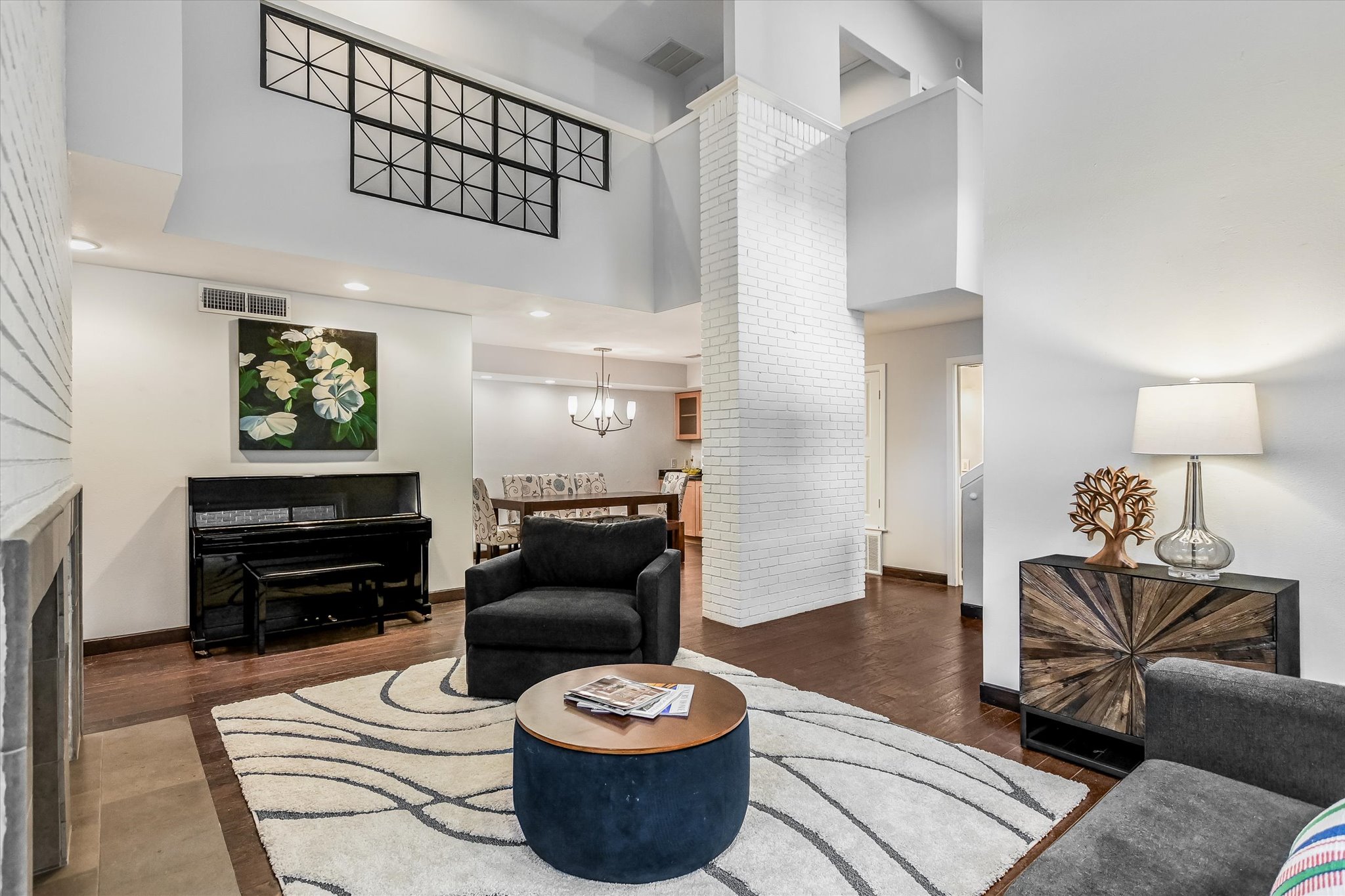 5622 Parade Ridge Austin, TX 78731 - Photo 7 of 24 Living room with a high ceiling, a fireplace, recessed lighting, a chandelier over the dining space