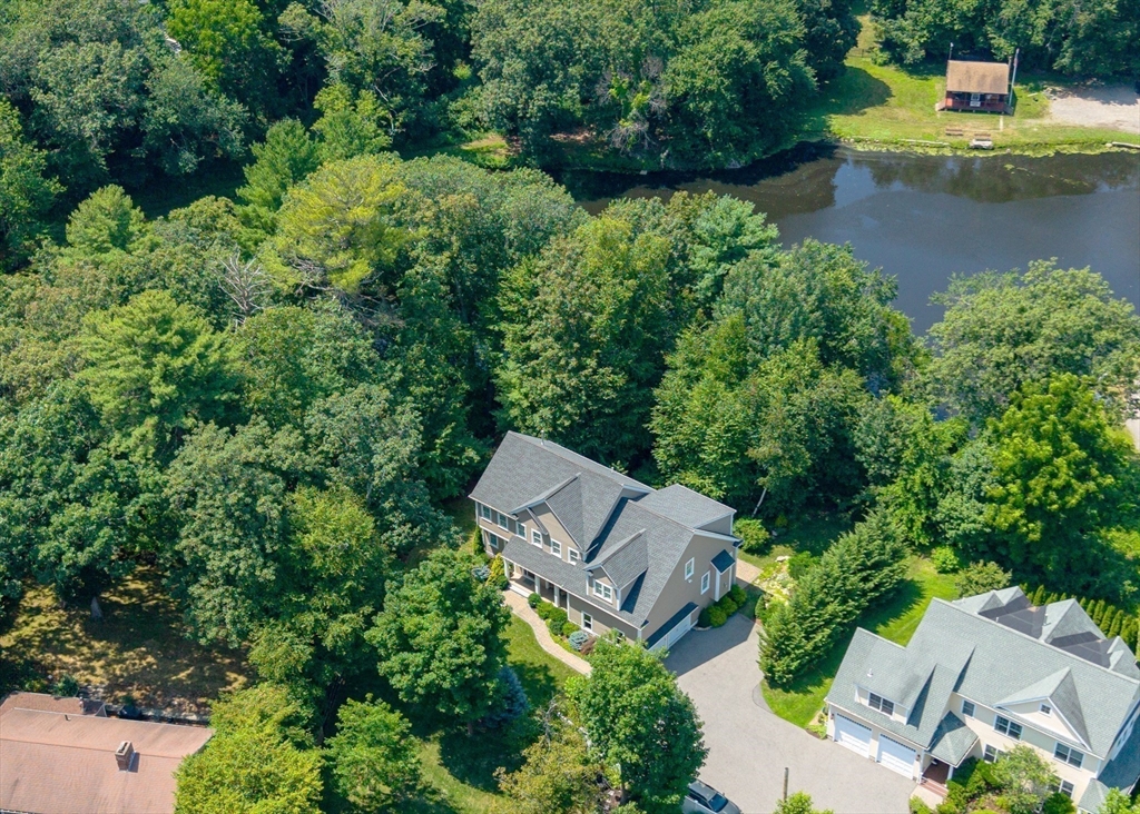 an aerial view of a house with a yard and lake view