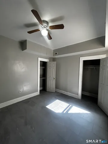 a view of empty room with window and ceiling fan