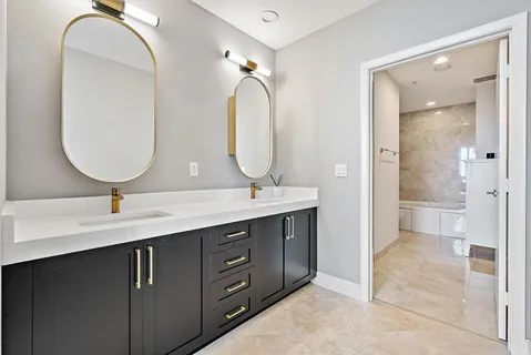 a bathroom with a double vanity sink mirror and shower
