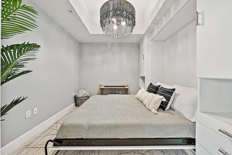 a bedroom with a bed and a chandelier