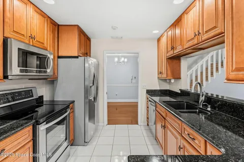 a kitchen with granite countertop a sink stove and refrigerator