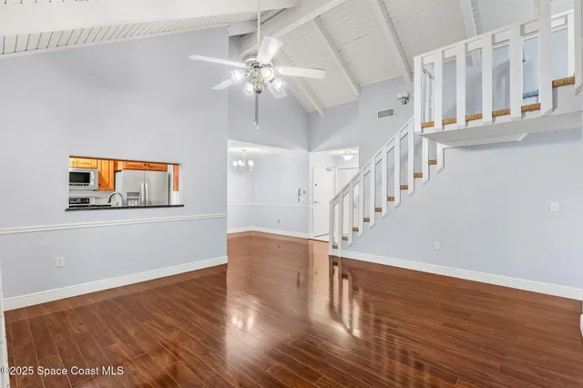 a view of staircase with wooden floor and fan