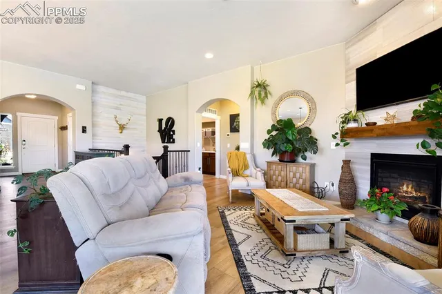a living room with furniture a flat screen tv and a fireplace
