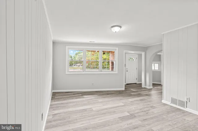 a view of empty room with window and wooden floor
