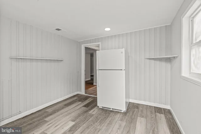 a view of a backyard with a tree and wooden fence