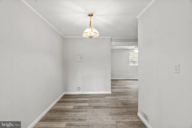 an empty room with a window and wooden floor