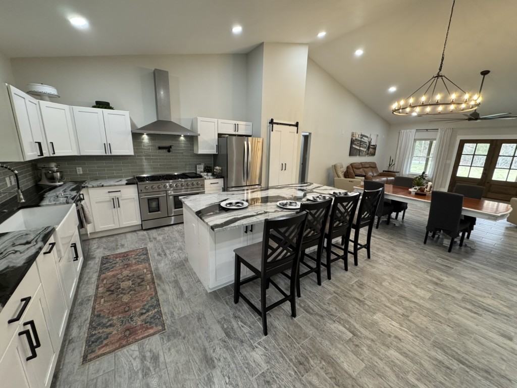 767 Potter Road Dickson, TN 37055 - Photo 9 of 30 a kitchen with stainless steel appliances a dining table chairs stove refrigerator and cabinets