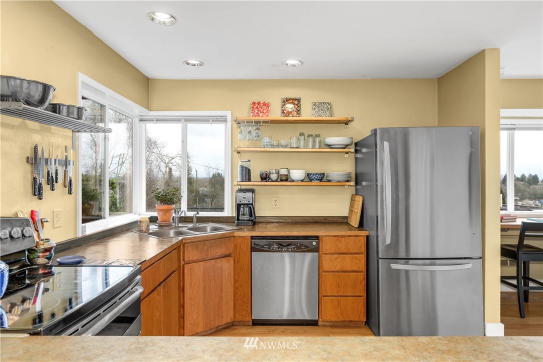 2418 East Roy Street Seattle, WA 98112 - Photo 13 of 32 a kitchen with stainless steel appliances granite countertop a refrigerator and a sink