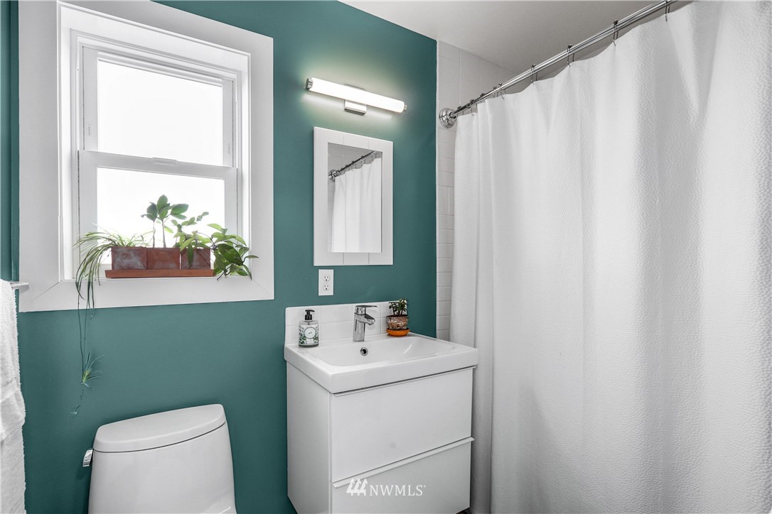 2418 East Roy Street Seattle, WA 98112 - Photo 23 of 32 a bathroom with a sink a toilet and a window