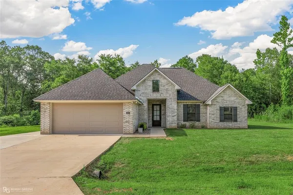 a front view of house with yard and green space
