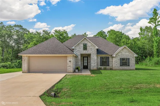 a front view of house with yard and green space