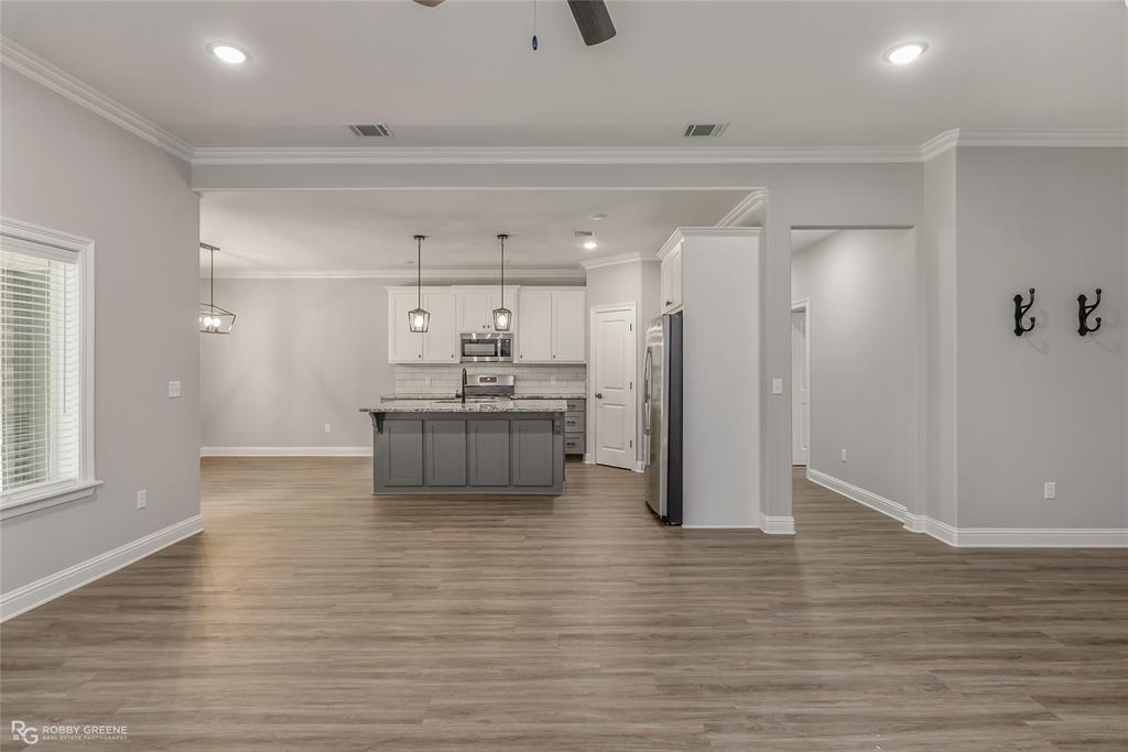 1013 VOSS Road Stonewall, LA 71078 - Photo 12 of 32 a view of a kitchen with kitchen island a sink wooden floor and a refrigerator