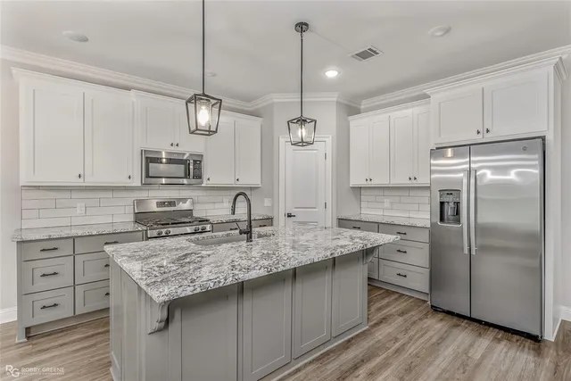 a kitchen with stainless steel appliances granite countertop a sink stove and refrigerator