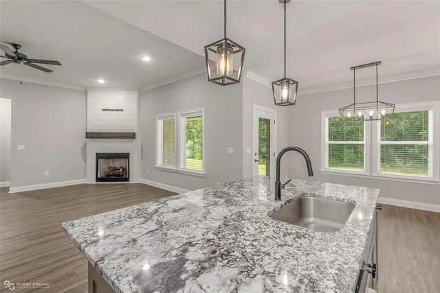a kitchen with a faucet a chandelier and living room view