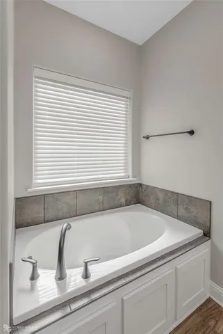 a bathroom with a bathtub and next to a window