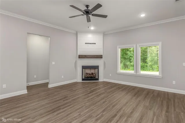 a view of an empty room with a window and fireplace