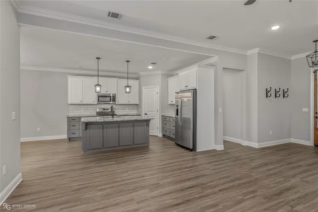 a kitchen with stainless steel appliances a refrigerator and a stove top oven