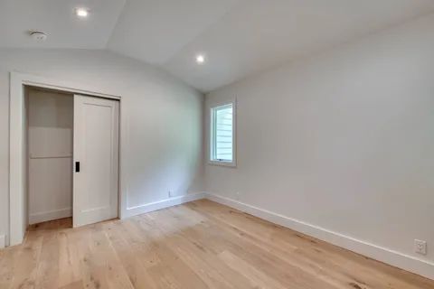 an empty room with wooden floor and window