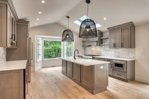 a kitchen with stainless steel appliances granite countertop a sink a stove and a wooden floors