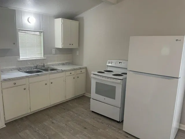 a kitchen with appliances a sink and a window
