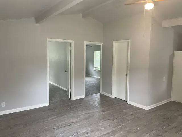 an empty room with wooden floor and mirror