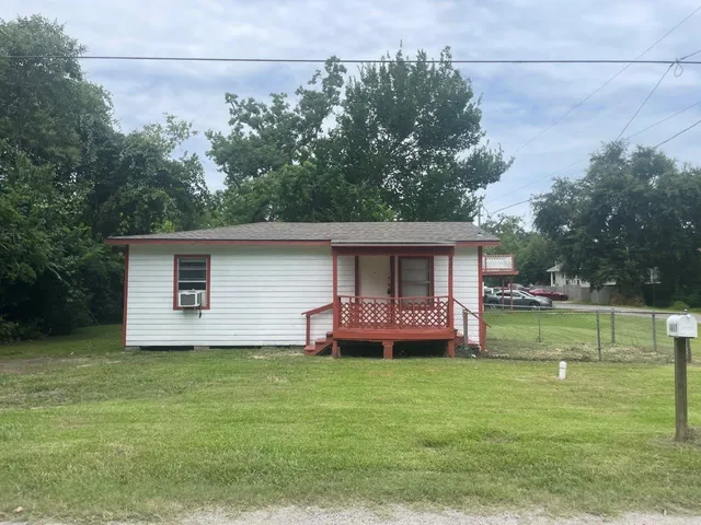 a front view of house with yard and trees in the background