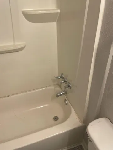 a bath tub sitting next to a white toilet