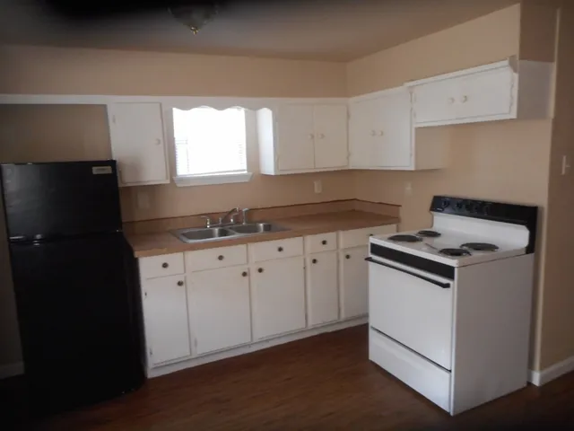 a kitchen with granite countertop white cabinets and black appliances