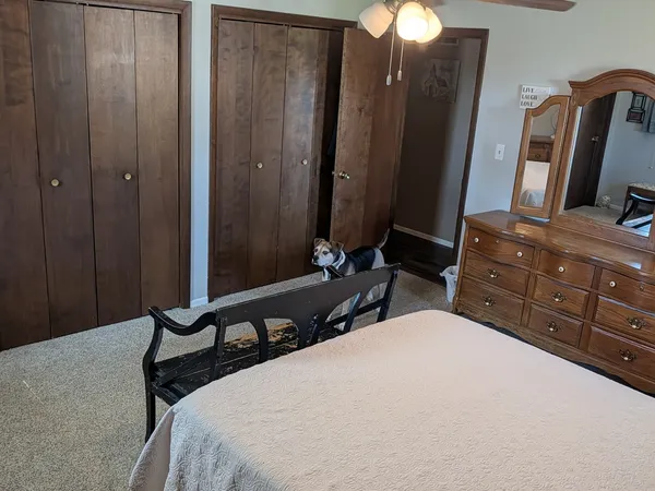 a bedroom with a bed and a mirror on dresser