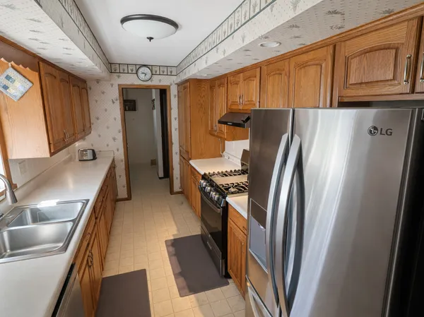 a kitchen with stainless steel appliances granite countertop a refrigerator and a sink