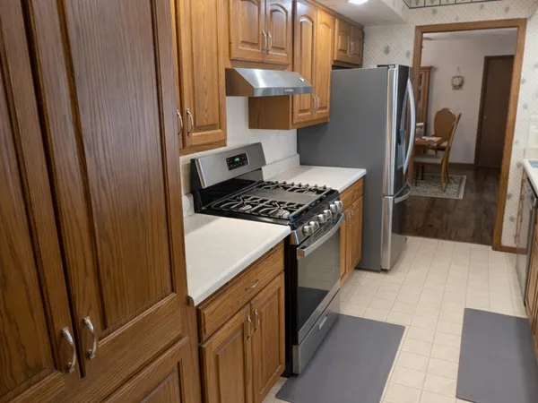 a kitchen with stainless steel appliances granite countertop a refrigerator and a stove