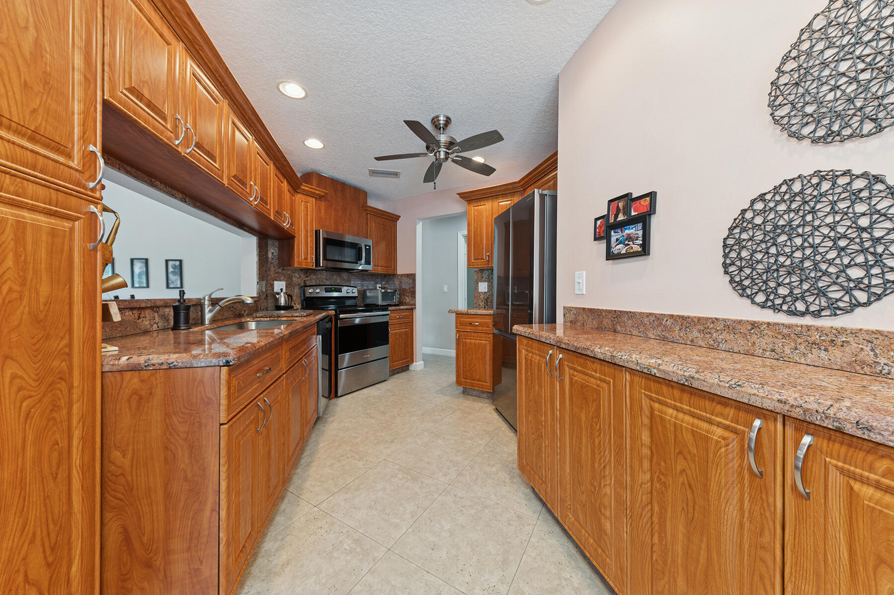 6276 Sweet Maple Lane Boca Raton, FL 33433 - Photo 6 of 14 a large kitchen with stainless steel appliances granite countertop a stove a sink dishwasher and a refrigerator with wooden floor