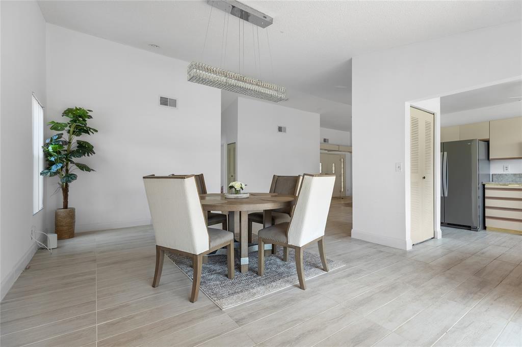 9477 Burlington Place Boca Raton, FL 33434 - Photo 7 of 40 a view of a dining room with furniture and a potted plant