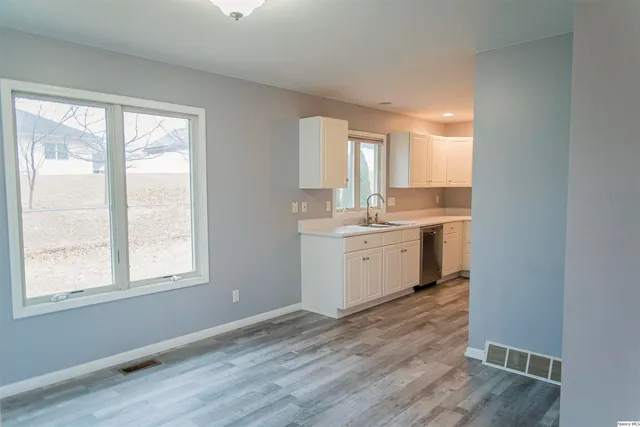 a view of a kitchen with wooden floor and electronic appliances