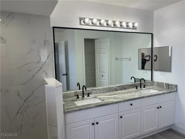a bathroom with a granite countertop sink and a mirror
