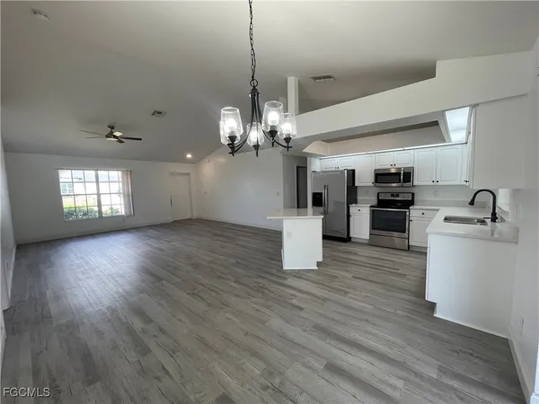 a view of a kitchen with furniture and wooden floor