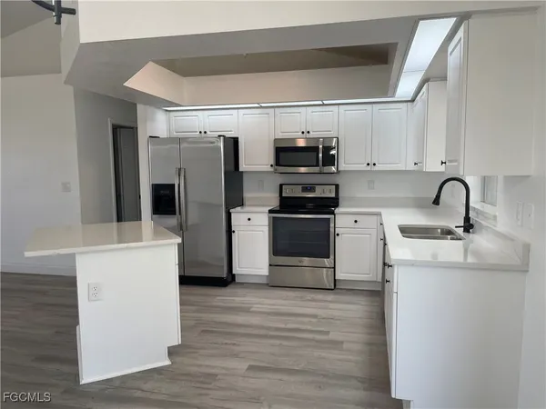a kitchen with refrigerator cabinets and wooden floor