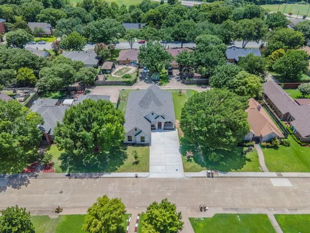 an aerial view of a house with a yard and couple of flower plants