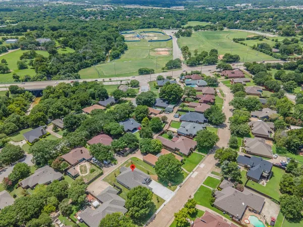 an aerial view of residential houses with outdoor space and street view