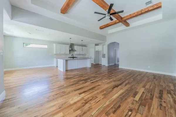 a view of a kitchen with wooden floor and a ceiling fan